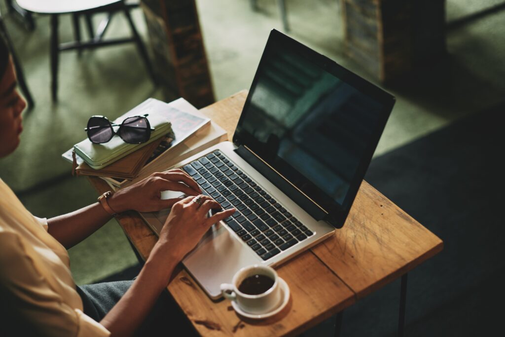 unrecognizable asian woman sitting cafe working laptop min